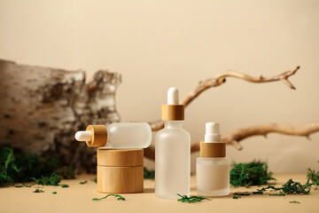 Transparent dropper bottles with natural cosmetics and jar of moisturizers cream. Natural beauty products set.