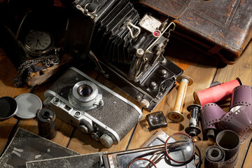 An old camera in a composition on an old background, on a table