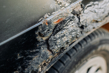 A fragment of a rusty car fender. Aggressive corrosion. Selective focus. Top view