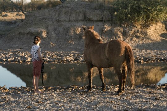 nena y caballo por cruzar un arrollo en el campo