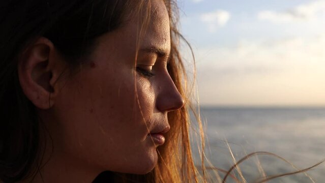 Portrait of a young woman by the sea at sunset. I'm looking forward to it.