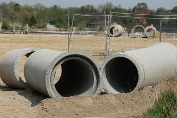 Duże betonowe rury na system kanalizacyjny na budowie.  - obrazy, fototapety, plakaty