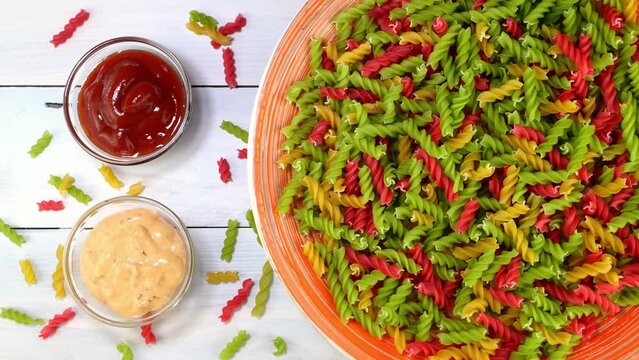 Multicolored uncooked raw italian fusilli pasta.