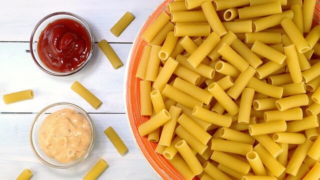 Uncooked raw italian rigatoni pasta rotating.