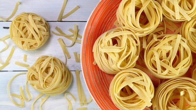 Uncooked raw italian tagliatelle pasta rotating.