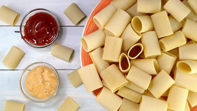 Uncooked raw italian paccheri pasta rotating.