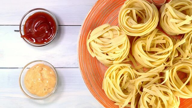 Uncooked raw italian tagliatelle pasta rotating.