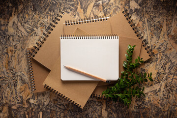 Notebook and branch with leaf on chipboard plywood background texture. Recycling concept - 503573393