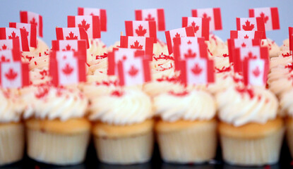 Canada flags decorate cupcakes with icing to celebrate Canada Day. 