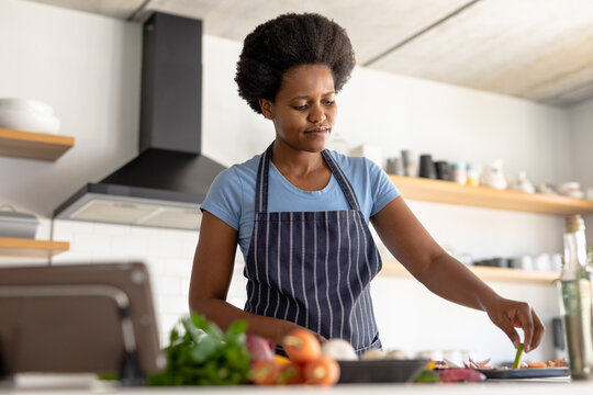 African american mid adult woman preparing food in kitchen at home