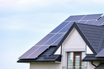 Residential house with rooftop covered with solar photovoltaic panels for producing of clean...
