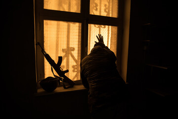 Conceptual photo of war between Russia and Ukraine. Ukraine and Russia flags on windowsill at...