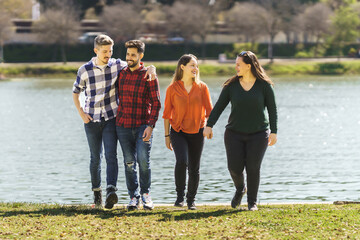lesbian couple and gay couple strolling near a river