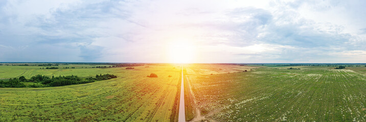 Asphalt highway through green summer field. Aerial panorama view