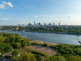 Fototapeta na wymiar widok z lotu ptaka na centrum Warszawy, panorama miasta, wieżowce i rzekę Wisła, wiosna, zielone drzewa i niebieskie niebo