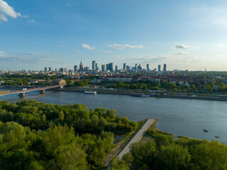 widok z lotu ptaka na centrum Warszawy, panorama miasta, wieżowce i rzekę Wisła, wiosna, zielone drzewa i niebieskie niebo - obrazy, fototapety, plakaty
