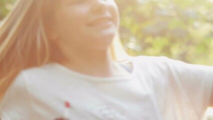 Happy young girl spinning around enjoying in the sunlight in park. Child having fun outdoors. Happiness in nature - Powered by Adobe