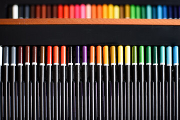 Set of colored pencils arranged in gradient with artistic copy space.