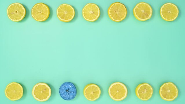 Blue sliced lemon move and replace yellow lemons on cyan background. Flat lay Stop motion