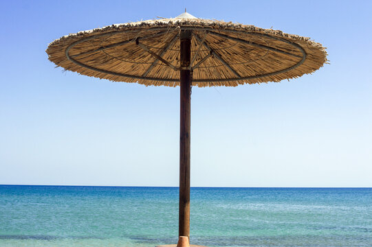 Straw sun umbrella at the beach with breathtaking sea view in Zephyros beach, Greece