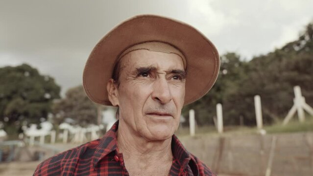 Latin farmer man in the casual shirt in the farm on the farm background. Cinematic 4K