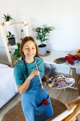 Woman preparing tasty green smoothie in kitchen