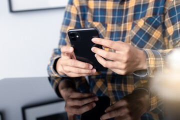 using cell phone hand holding mobile texting message contact us.chatting,search internet information in office.technology device communication connecting