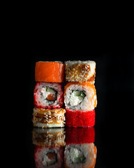 Sushi Rolls Set, maki, philadelphia and california rolls, on a Black background.