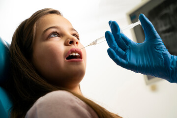 Little girl getting dental anesthesia before treatment 