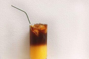 Black orange coffee in glass with stainless steel straw for drink on white background. Concept for reduce plastic pollution and support green eco friendly 