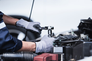 Professional mechanic working on the engine of the car in the garage. Car repair service.