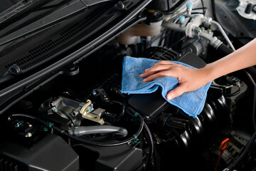 Fototapeta na wymiar hand of a man holding a blue cloth caring, maintenance car and cleaning And engine car room
