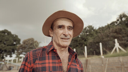 Latin farmer man in the casual shirt in the farm on the farm background.