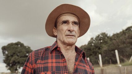 Latin farmer man in the casual shirt in the farm on the farm background.