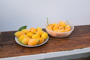 Mayongchid or Plum Mango on wooden table , Sweet yellow Marian plum.
