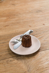 Dessert Canelé on white plate at cafe ,Caneles de bordeaux.