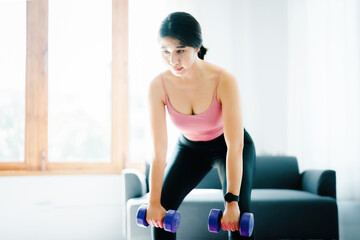 Fototapeta premium stress relief, , breathing exercises, meditation, portrait of Asian healthy woman lifting weights to strengthen her muscles after work.