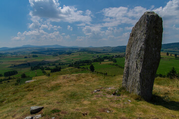 Beautiful view of standing stone on the hill under the blue cloudy sky