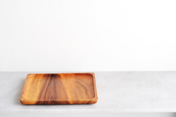 Empty round wooden plate on white cement table and white wall background, Blank wood tray banner for food display montage, template, mock up