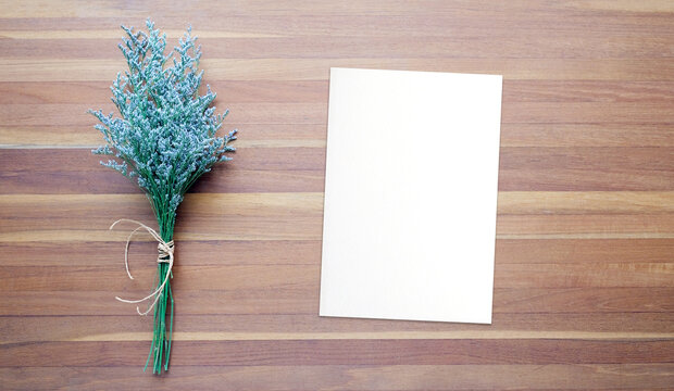 Flower bouquet and blank note paper on wood background, banner with copy space, top view, flat lay