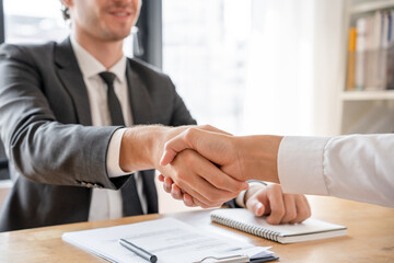 Businessman and job seekers shake hands after agreeing to accept a job and approve it as an...