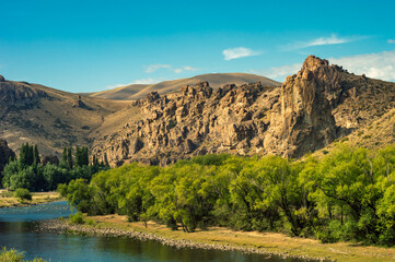 Mapuche community valley of mountains and river with rock formations making balance.
