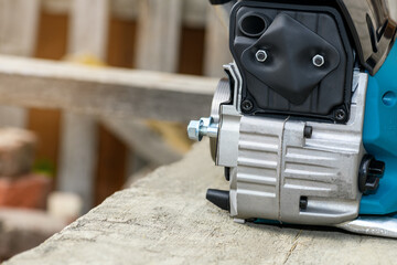 Part of a chainsaw, copy space. Chainsaw exhaust silencer closeup