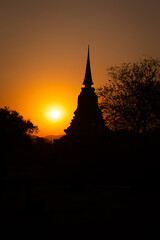Obraz premium Sunset at Wat Mahathat buddha and temple in Sukhothai Historical Park