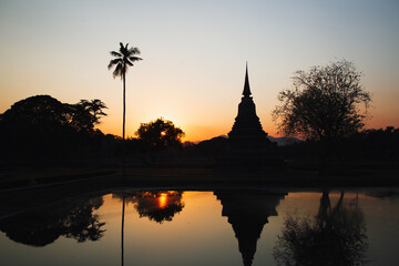 Fototapeta na wymiar Sunset at Wat Mahathat buddha and temple in Sukhothai Historical Park