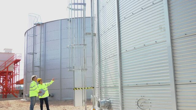 Teamwork civil engineer plan the construction of water tanks  steel metal sheet for tap water water storage 
of industrial estate. Utilities of industry.