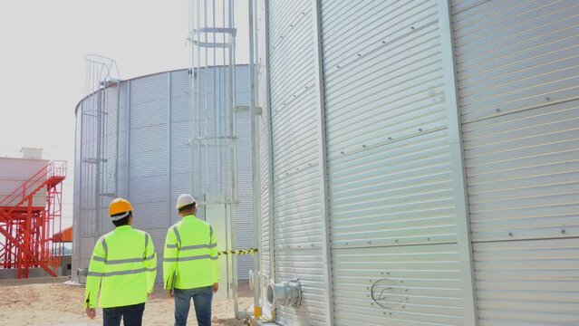 Teamwork civil engineer plan the construction of water tanks  steel metal sheet for tap water water storage 
of industrial estate. Utilities of industry.
