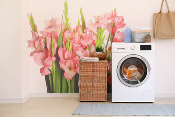 Interior of modern bathroom with washing machine near light wall with printed flowers