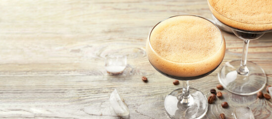Glasses of tasty espresso martini cocktail on wooden table