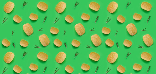 Tasty potato chips and herbs on green background. Texture for design